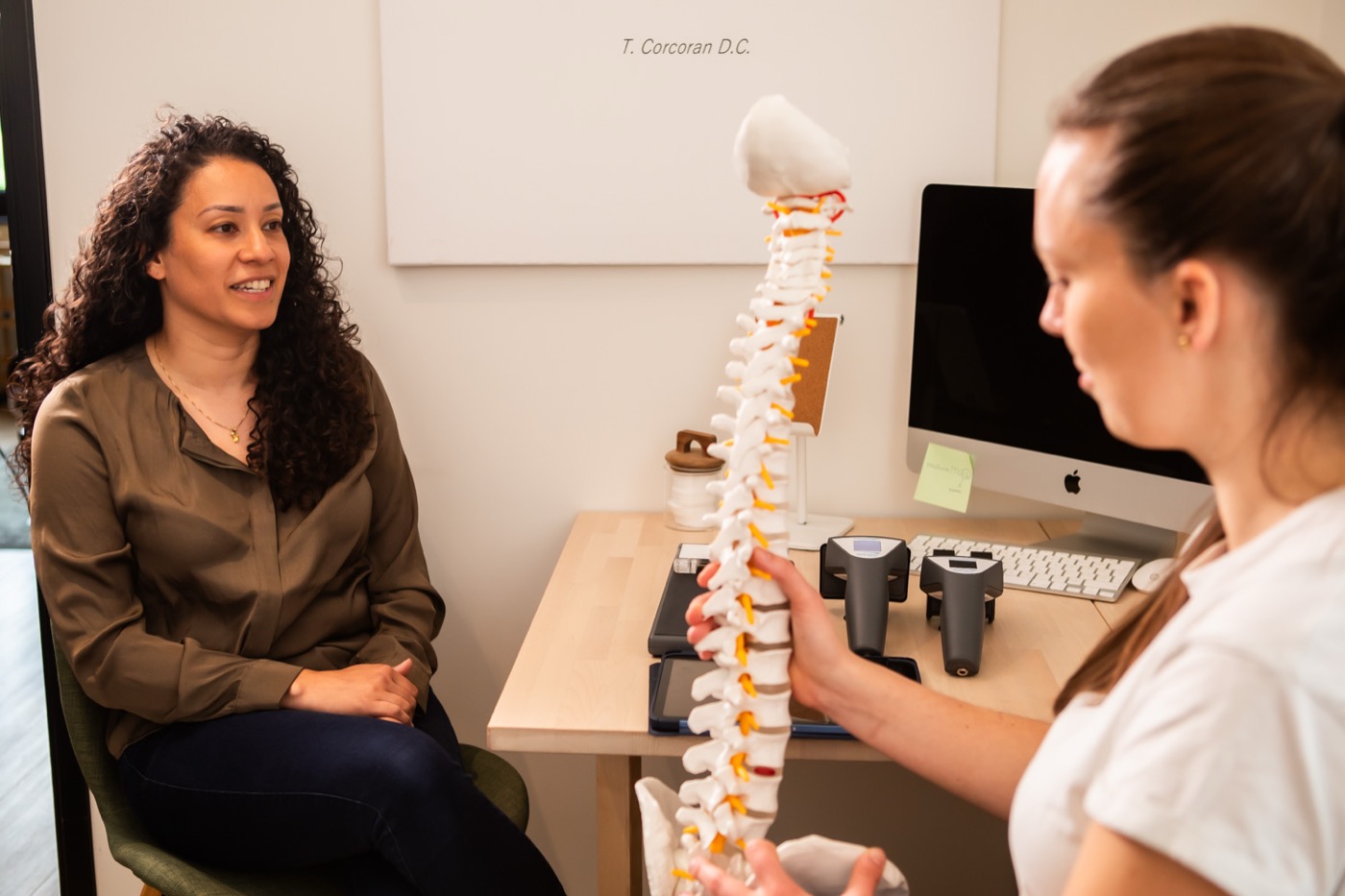 Chiropractor legt met een wervelkolommodel uit wat de scan laat zien bij TOPCHIRO Eindhoven